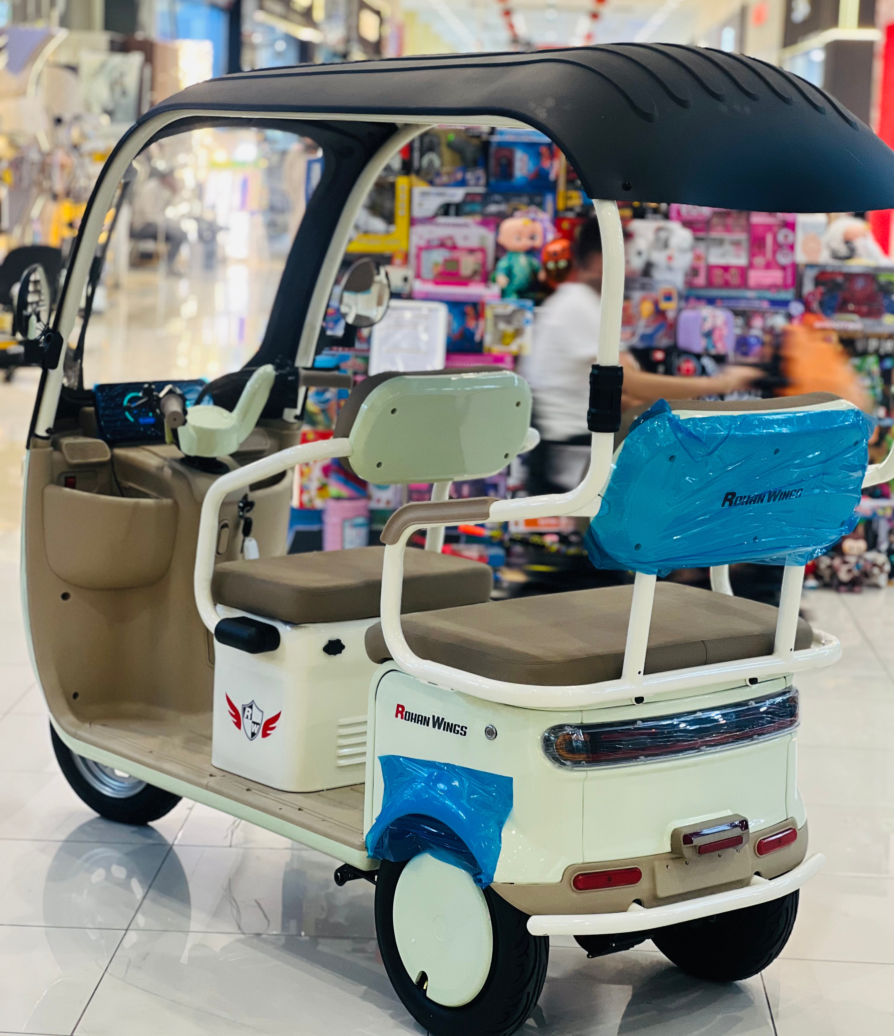 Three-wheeled electric vehicle with a canopy in a store setting